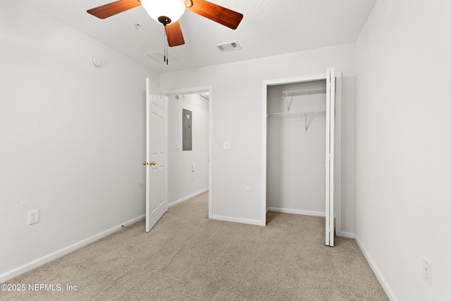 unfurnished bedroom with light carpet, a textured ceiling, ceiling fan, electric panel, and a closet