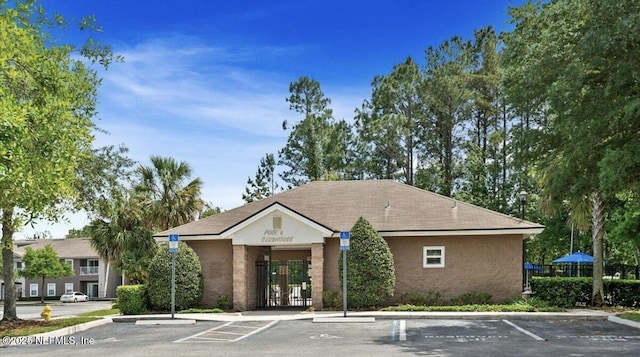 view of building exterior with uncovered parking and fence