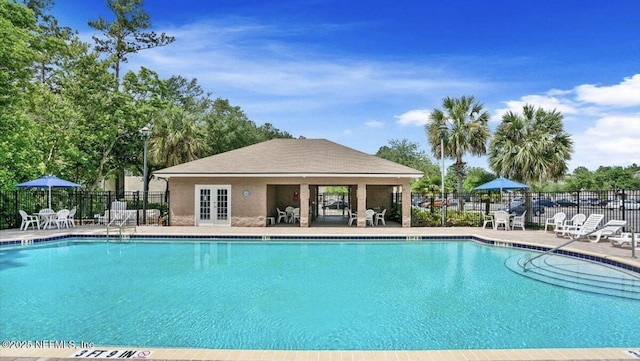 view of swimming pool with a patio and french doors