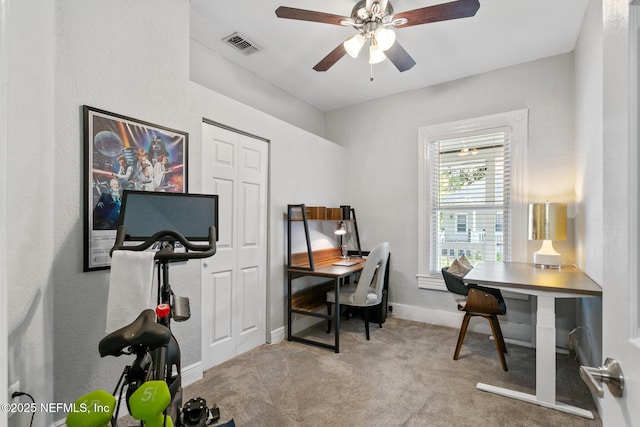 carpeted office space featuring ceiling fan