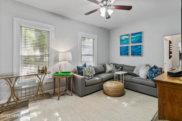 living room featuring ceiling fan, a healthy amount of sunlight, and light wood-type flooring