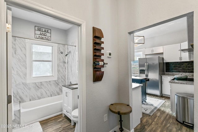 full bathroom with vanity, tiled shower / bath, decorative backsplash, toilet, and wood-type flooring