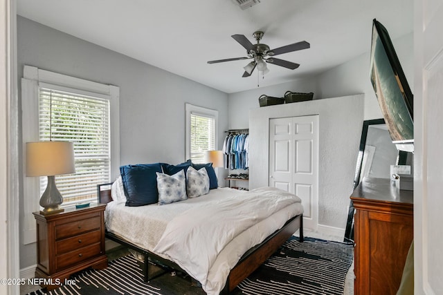 bedroom featuring multiple windows, ceiling fan, and a closet