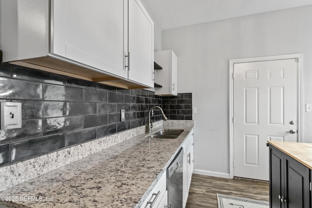 kitchen featuring white cabinets, stainless steel dishwasher, light stone countertops, and sink