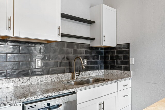 kitchen featuring dishwasher, sink, light stone counters, decorative backsplash, and white cabinets