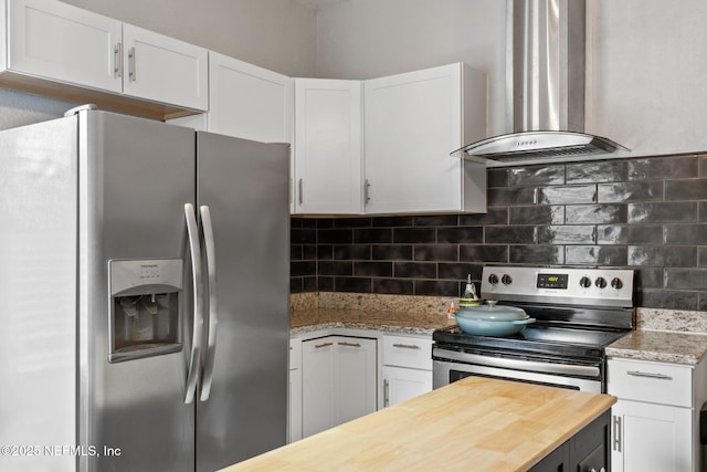 kitchen featuring white cabinets, wall chimney range hood, and appliances with stainless steel finishes