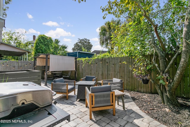 view of patio / terrace with a hot tub and an outdoor hangout area