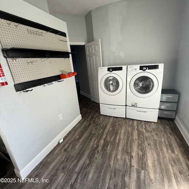 washroom with washer and dryer and dark wood-type flooring