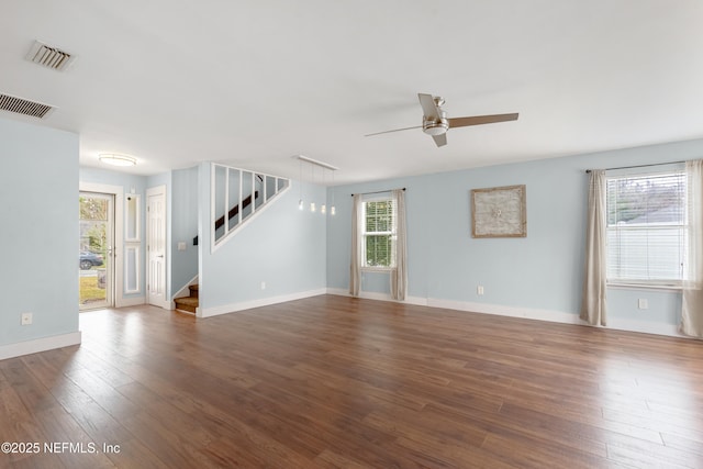 unfurnished room featuring a wealth of natural light, dark hardwood / wood-style floors, and ceiling fan