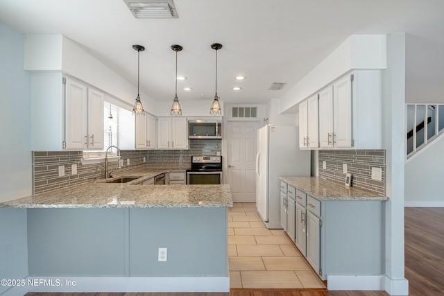 kitchen featuring decorative light fixtures, sink, white cabinets, kitchen peninsula, and stainless steel appliances