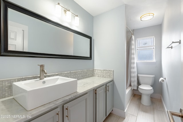 full bathroom featuring vanity, shower / tub combo with curtain, backsplash, and toilet