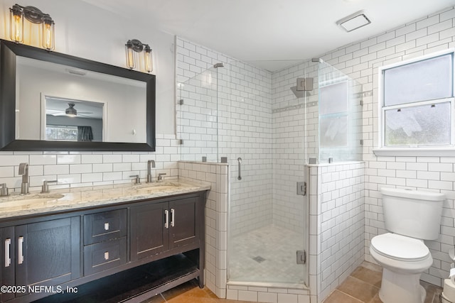 bathroom with walk in shower, tile patterned floors, toilet, and tile walls