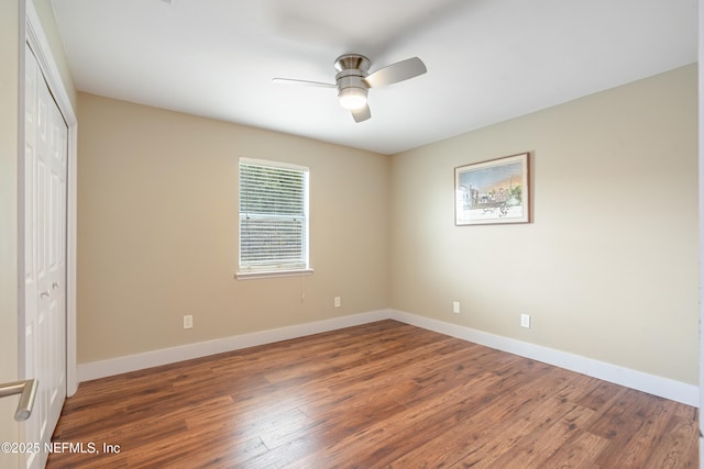 unfurnished bedroom with a closet, dark hardwood / wood-style floors, and ceiling fan