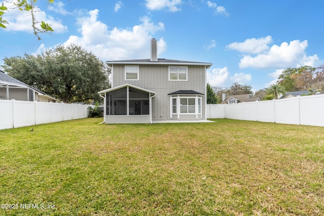 rear view of property with a sunroom and a yard