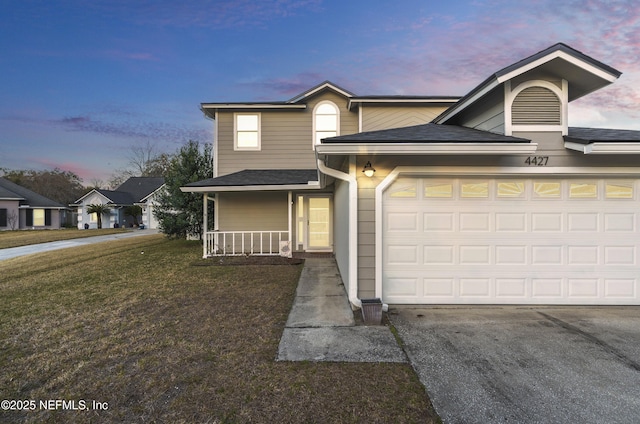 view of front of home featuring a yard, a garage, and covered porch