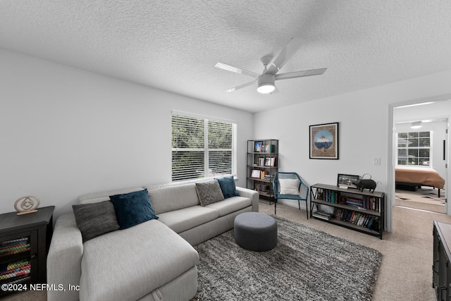 living room with a textured ceiling and ceiling fan