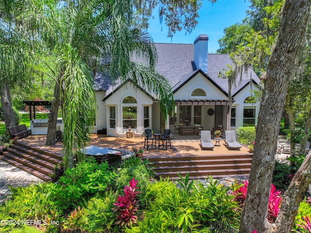 rear view of house featuring an outdoor kitchen and a deck