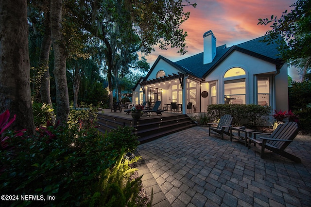 back house at dusk with a patio area