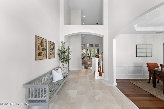 foyer entrance with a high ceiling and crown molding