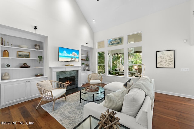 living room with high vaulted ceiling, built in features, and dark hardwood / wood-style floors