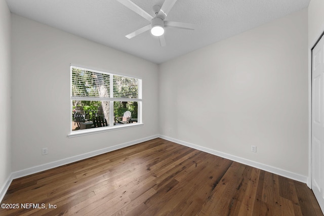 spare room with ceiling fan and dark wood-type flooring