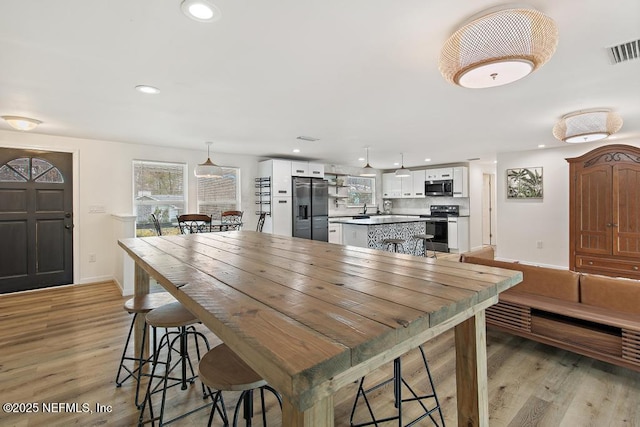 dining space featuring sink and light wood-type flooring