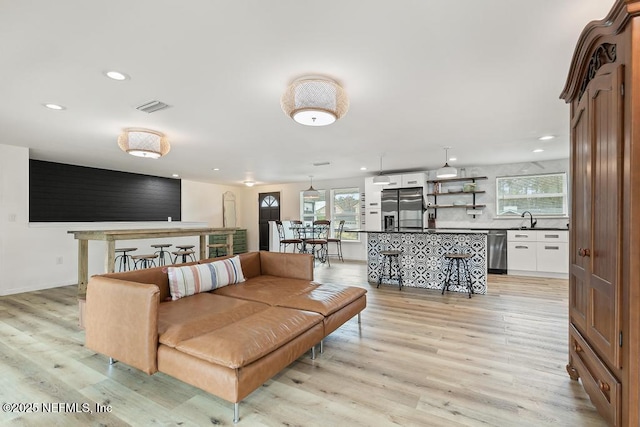 living room with sink and light wood-type flooring