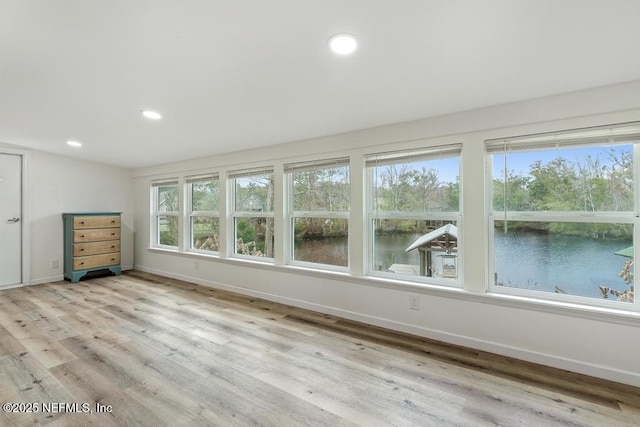 interior space featuring light hardwood / wood-style flooring and a water view