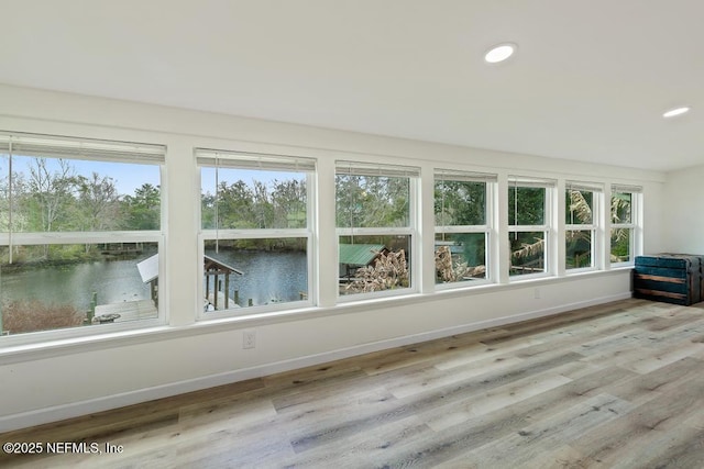 unfurnished sunroom featuring a water view