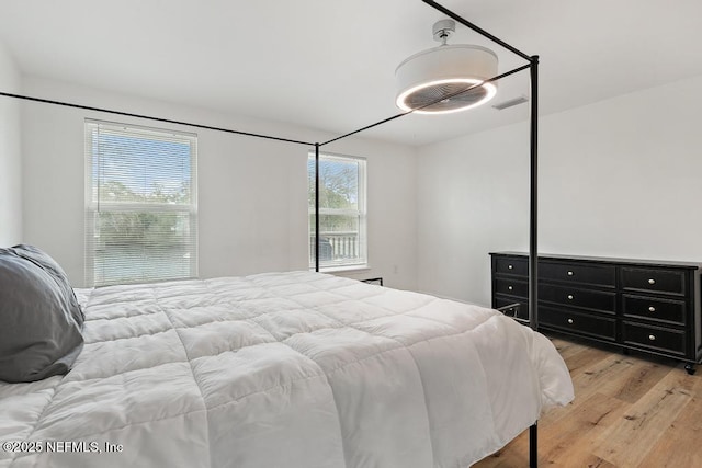 bedroom with multiple windows and light wood-type flooring