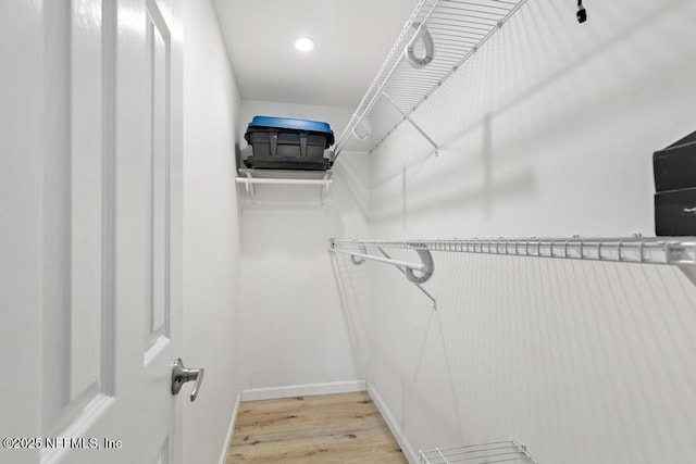 spacious closet with light hardwood / wood-style flooring