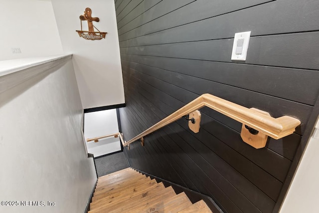 staircase featuring hardwood / wood-style flooring and wood walls