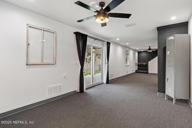 spare room with dark colored carpet and ceiling fan