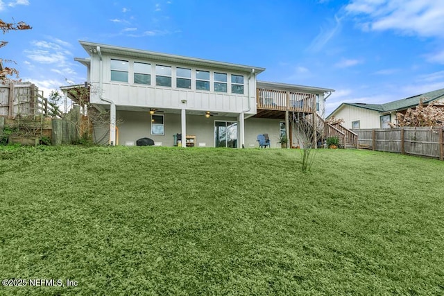 rear view of property with a lawn and a deck