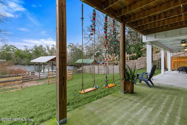 view of yard featuring a patio area, a water view, and ceiling fan