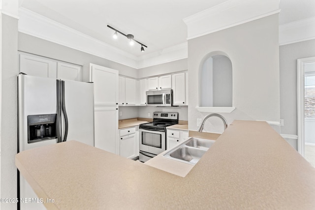 8550 Touchton Rd Unit 127, Jacksonville, FL 32216 - kitchen featuring ornamental molding, appliances with stainless steel finishes, light countertops, white cabinets, and a peninsula