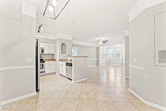 8550 Touchton Rd Unit 127, Jacksonville, FL 32216 - kitchen with a peninsula, ceiling fan, open floor plan, white cabinets, and crown molding