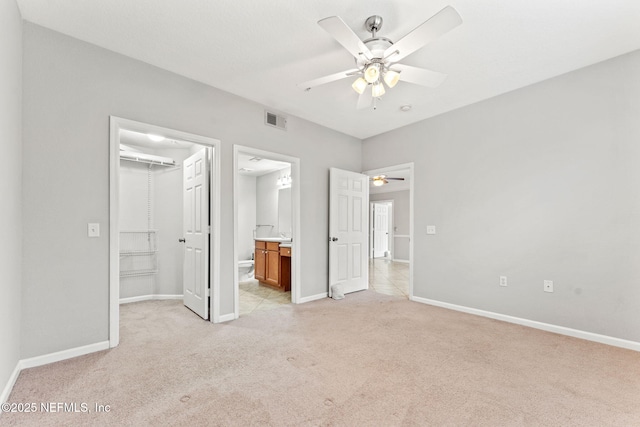 8550 Touchton Rd Unit 127, Jacksonville, FL 32216 - unfurnished bedroom with a spacious closet, light colored carpet, connected bathroom, and a ceiling fan