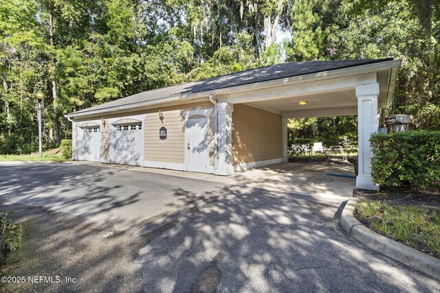 8550 Touchton Rd Unit 127, Jacksonville, FL 32216 - garage with driveway and view of scattered trees