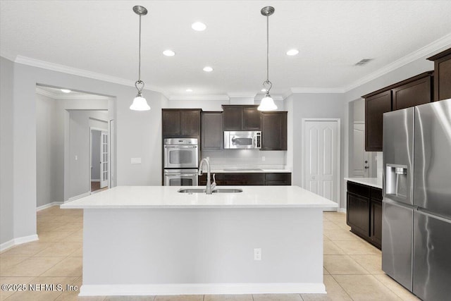 kitchen with appliances with stainless steel finishes, a center island with sink, and hanging light fixtures