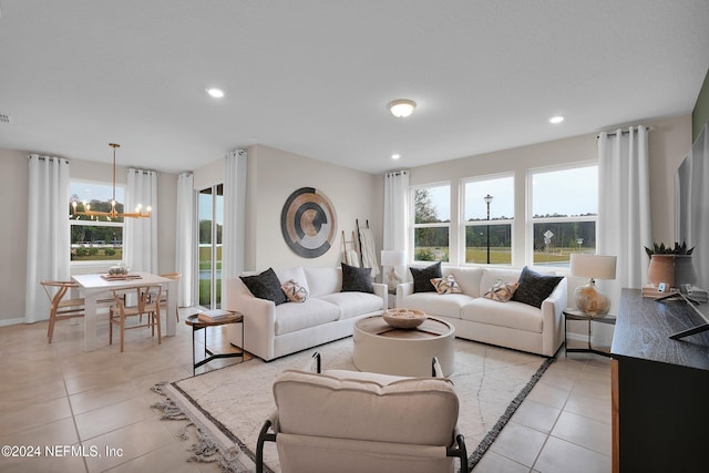 living room with light tile patterned flooring and an inviting chandelier