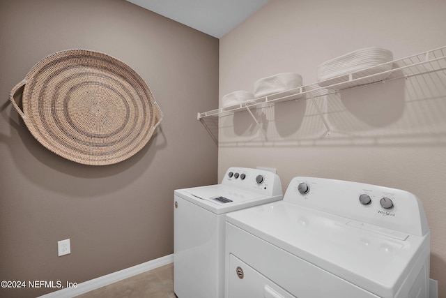 laundry room featuring washer and clothes dryer and light tile patterned flooring