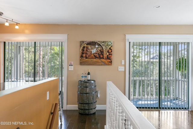 14 Ballard Ave, Saint Augustine, FL 32084 - hallway with dark wood-type flooring, rail lighting, and an upstairs landing