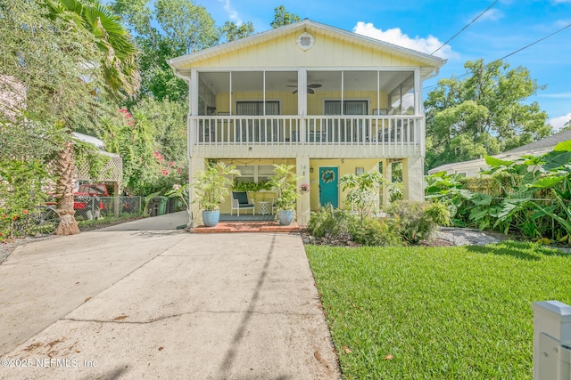 14 Ballard Ave, Saint Augustine, FL 32084 - view of front of house with a sunroom, a ceiling fan, concrete driveway, and a front yard