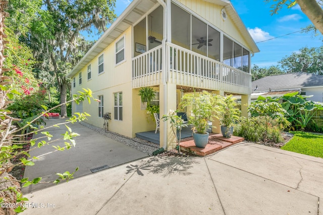 14 Ballard Ave, Saint Augustine, FL 32084 - view of front of house featuring a sunroom, a patio area, a ceiling fan, and stucco siding