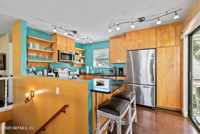 14 Ballard Ave, Saint Augustine, FL 32084 - kitchen featuring appliances with stainless steel finishes, open shelves, dark countertops, dark wood-style flooring, and a kitchen breakfast bar
