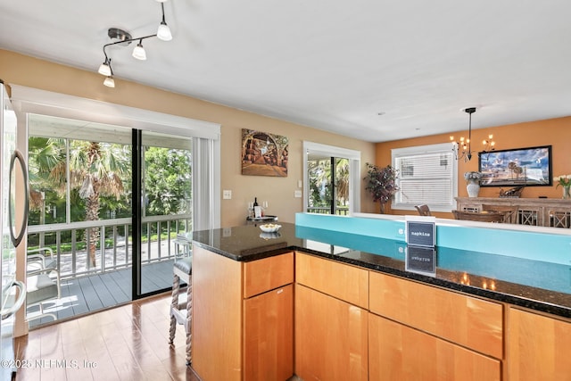 14 Ballard Ave, Saint Augustine, FL 32084 - kitchen with dark stone counters, a chandelier, hanging light fixtures, and light wood finished floors