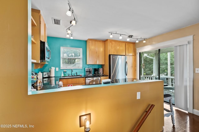 14 Ballard Ave, Saint Augustine, FL 32084 - kitchen featuring appliances with stainless steel finishes, track lighting, a peninsula, tasteful backsplash, and a kitchen bar