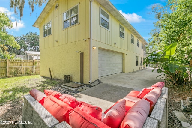 14 Ballard Ave, Saint Augustine, FL 32084 - view of side of property featuring an attached garage, outdoor lounge area, driveway, stucco siding, and board and batten siding