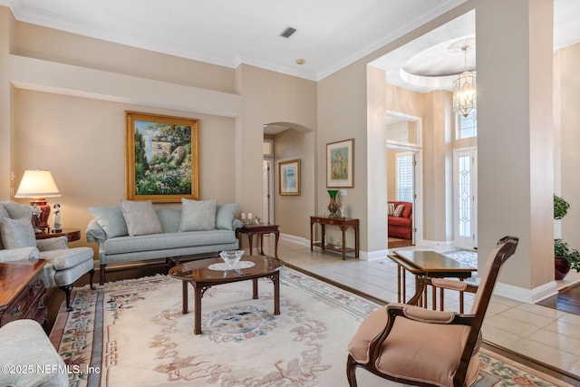 tiled living room with crown molding and a chandelier